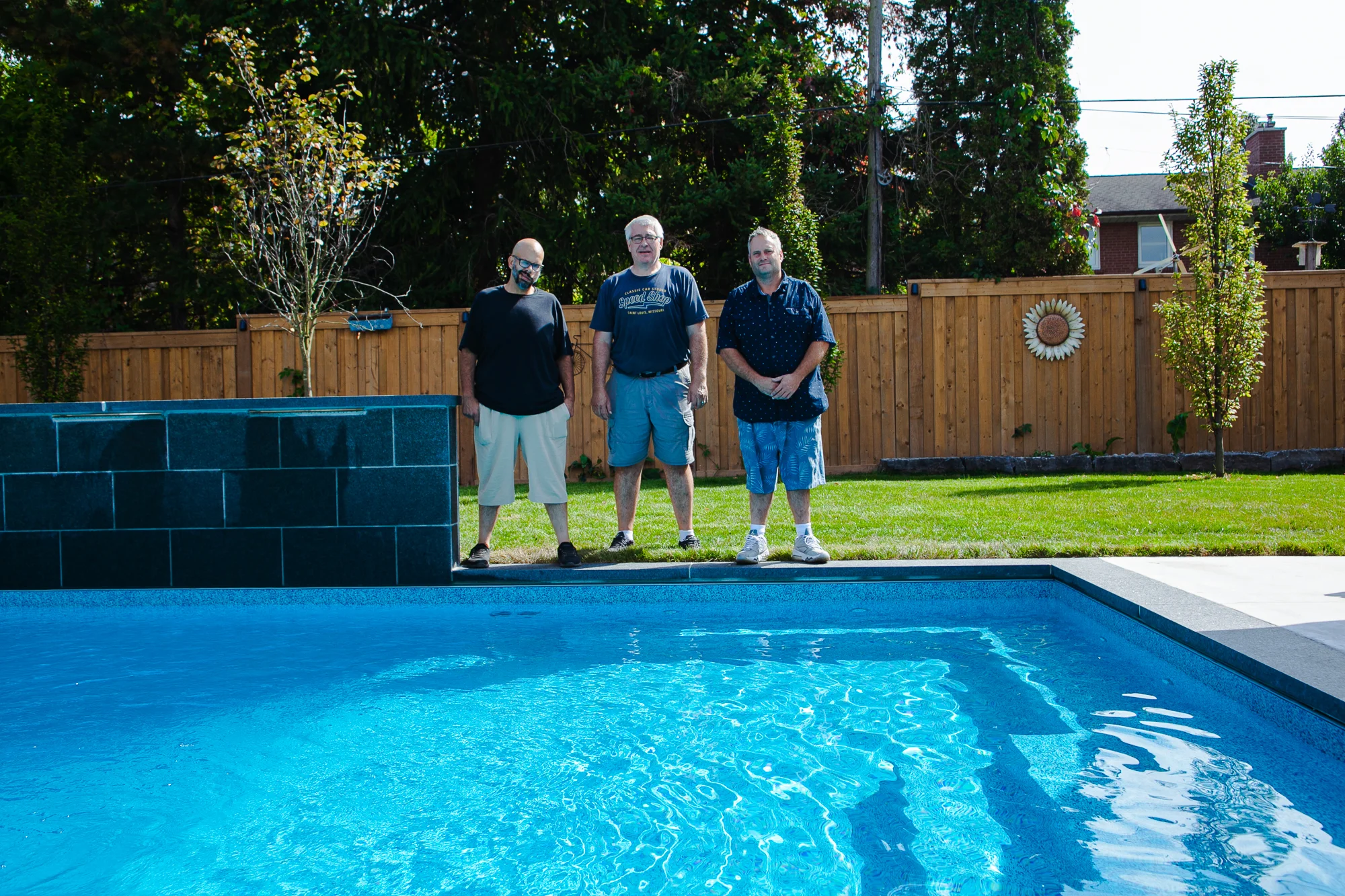Completed inground pool with cedar privacy fence and waterfall feature in Mississauga