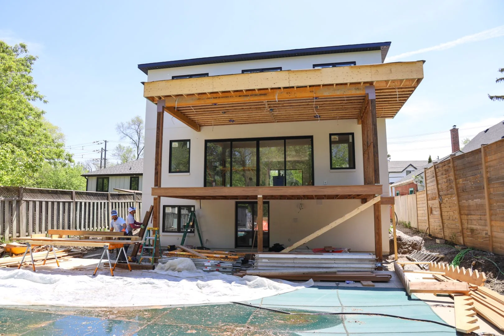 Deck framing and support posts built over the pool deck area during a backyard renovation