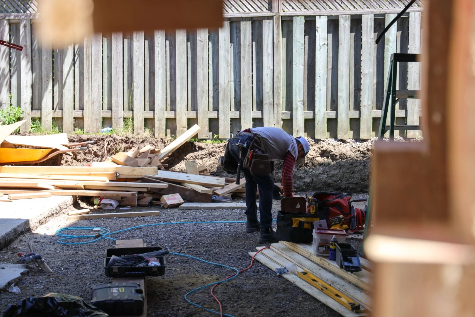 Deck and pergola framing beside a pool during a full backyard renovation