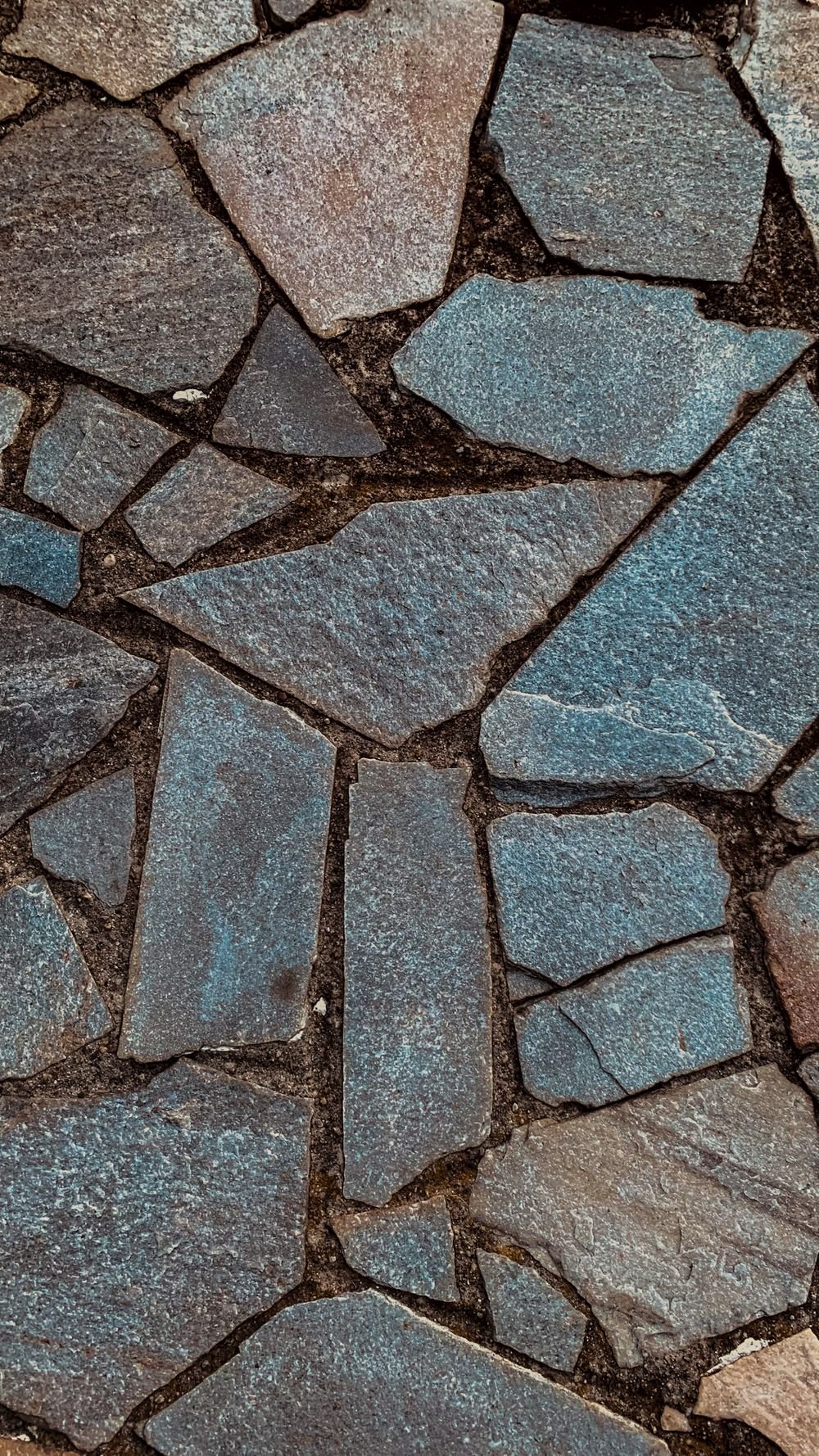 Close-up of irregular natural flagstone paving in grey and blue tones